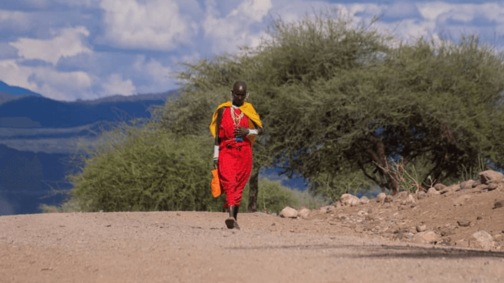 Maasai Woman walking a dusty road