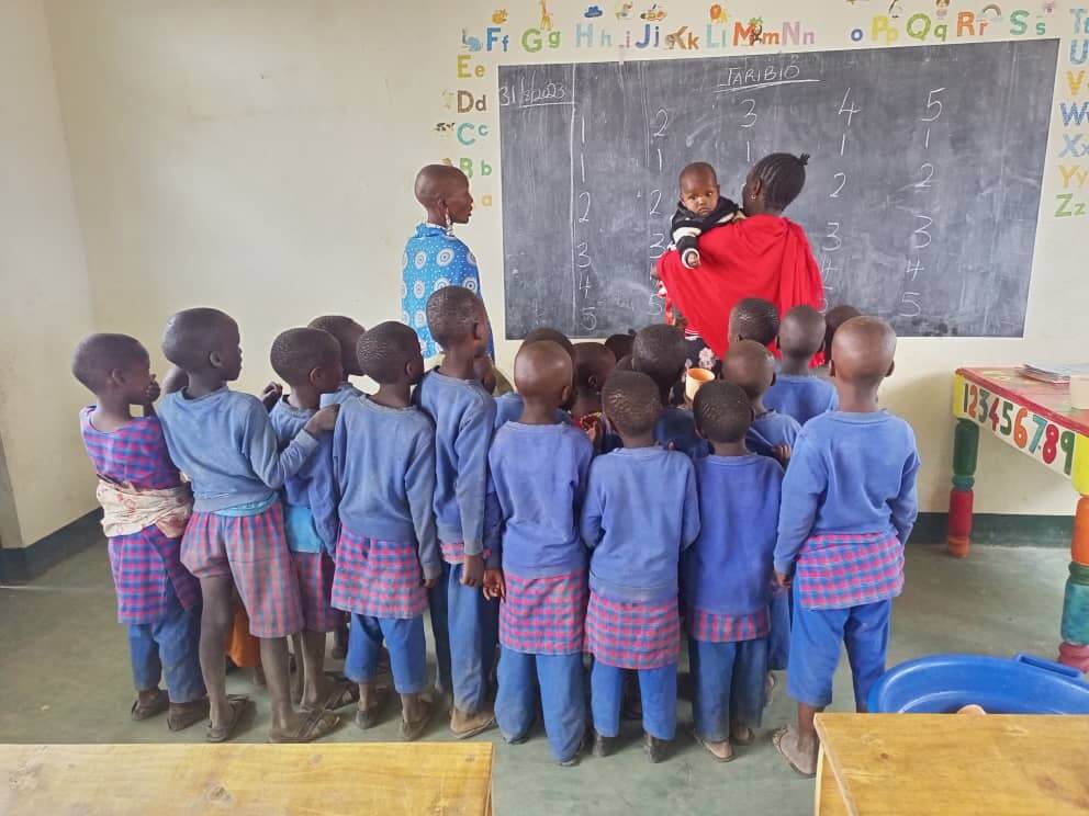 Class in front of board with teachers
